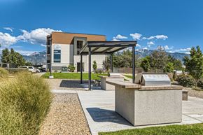 Midvale apartment for rent - a picnic area with a grill and a building with mountains in the background