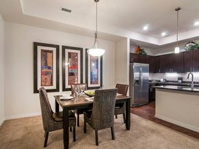Englewood apartment for rent - A dining room with a table and chairs and a kitchen in the background.