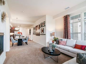 Englewood apartment for rent - A living room with a white couch, a black coffee table, and a dining table with chairs.