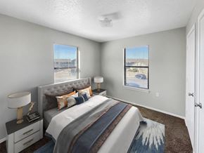 Albuquerque apartment for rent - A bedroom with a large bed and a window overlooking a parking lot.
