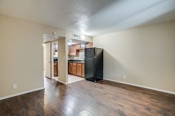 Phoenix apartment for rent - A kitchen with a black refrigerator and wooden floors.