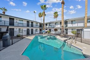Phoenix apartment for rent - A swimming pool in front of a building with palm trees.
