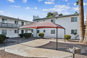 Phoenix apartment for rent - A red and white striped canopy is over a concrete patio.