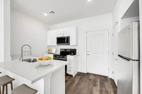 Youngtown apartment for rent - A modern kitchen with white cabinets and appliances.