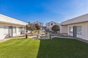 Youngtown apartment for rent - A modern building with a green lawn in front.