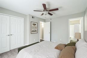 Little Rock apartment for rent - A bedroom with a white bed and a ceiling fan.