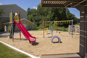 Little Rock apartment for rent - A playground with a red slide and a yellow and red climbing frame.