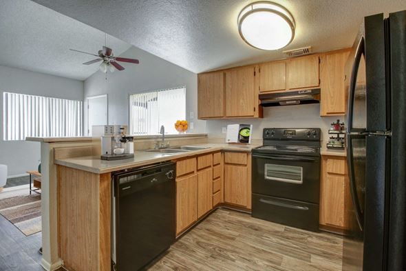 Casa Grande apartment for rent - A kitchen with wooden cabinets and black appliances.