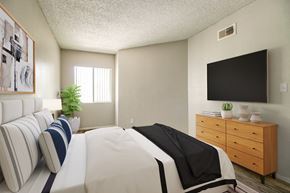 Casa Grande apartment for rent - A bedroom with a large bed and a flat screen TV mounted on the wall.