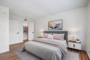 Tucson apartment for rent - A bedroom with a large bed and a painting on the wall.