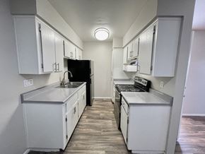 Phoenix apartment for rent - A kitchen with white cabinets and a black refrigerator.