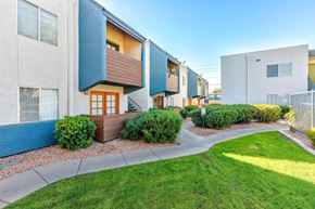Phoenix apartment for rent - A row of modern townhouses with a sidewalk and green grass in front.