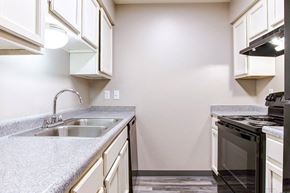 Little Rock apartment for rent - A kitchen with a black oven and a grey countertop.