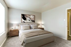 Little Rock apartment for rent - A bedroom with a large bed and a painting on the wall.
