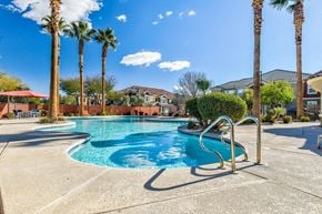 Las Vegas apartment for rent - A pool surrounded by palm trees and a clear blue sky.