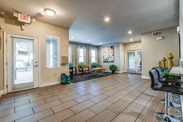 Las Vegas apartment for rent - A living room with a black leather chair and a bar stool.