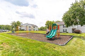 Kansas City apartment for rent - A playground with a green slide and a yellow swing set.