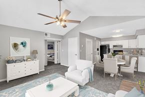 Kansas City apartment for rent - A living room with a ceiling fan and a dining area.