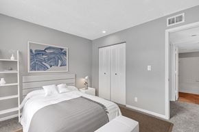 Kansas City apartment for rent - A bedroom with a large bed and a painting on the wall.