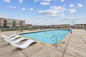 Johnstown apartment for rent - A large outdoor swimming pool with a white wave-like design on the edge.