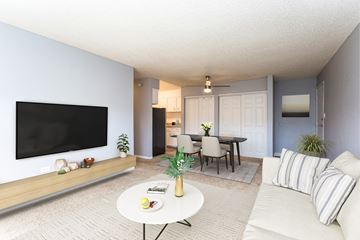 Thornton apartment for rent - A living room with a white couch, a coffee table, a flat screen TV, and a dining table with chairs.