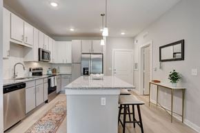 Apopka apartment for rent - an open kitchen with a large island with granite counter top and stainless steel appliances
