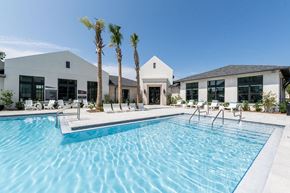 Santa Rosa Beach apartment for rent - a swimming pool with palm trees in front of a building