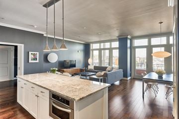 Washington apartment for rent - a kitchen with an island and a living room with a couch and a tv