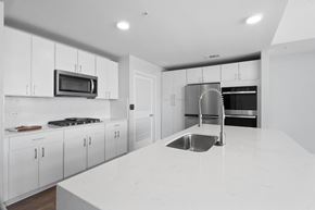 Austin apartment for rent - A modern kitchen with white cabinets and a white countertop.