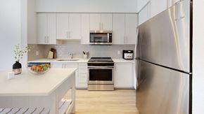 Plantation apartment for rent - a kitchen with stainless steel appliances and white cabinets