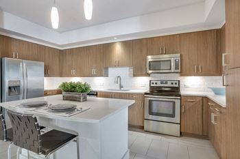 Modelhomes-chef-inspired kitchens with quartz counters and stainless steel appliances