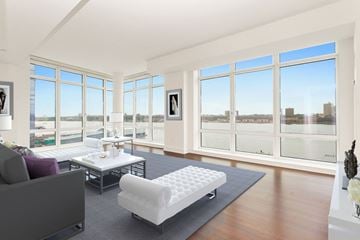 New York apartment for rent - an open living room with a view of the river and a couch and a table
