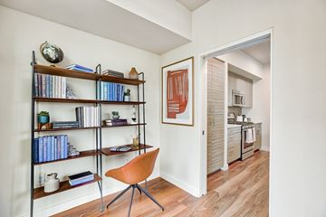 Seattle apartment for rent - a living room with a bookshelf and a doorway to a kitchen