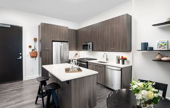A kitchen in a 555 waverly unit with an island and stools