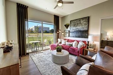 Plano apartment for rent - a living room with a pink couch and a sliding glass door