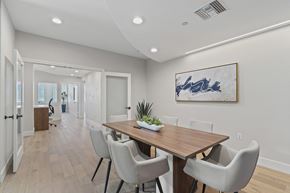Orange apartment for rent - a dining room with white chairs and a wooden table