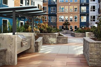 Inner courtyard lounge with grilling stations, festoon lighting, firepit and lounge seating