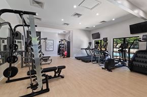 Fairfax apartment for rent - a gym with cardio equipment and a tv on the wall