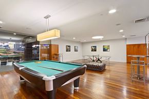 New York apartment for rent - A pool table is in the middle of a room with a green felt cloth.