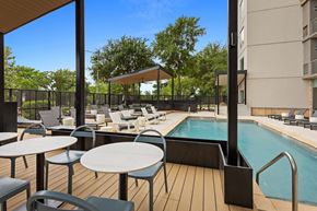 Austin apartment for rent - A pool area with a table and chairs.