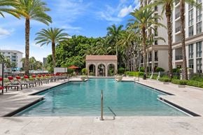 Doral apartment for rent - Resort-style swimming pool with private cabanas, lounge seating, palm trees, and waterfront views at Windsor at Doral, 4400 NW 79th Ave, Doral, FL 33166
