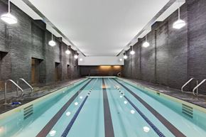 New York apartment for rent - A long indoor swimming pool with a brick wall on the side.