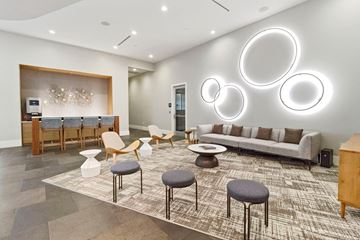 Dallas apartment for rent - a living room with couches and chairs and a bar with round mirrors
