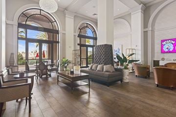 Doral apartment for rent - A modern living room with a large sofa and a TV screen.