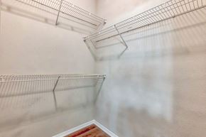 Charlotte apartment for rent - A walk in closet in a bedroom with white walls and metal shelves
