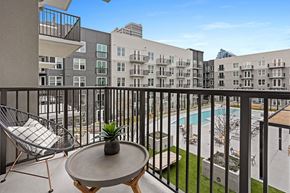 Atlanta apartment for rent - a balcony with a pool and a patio with chairs and a table