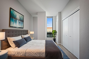 Denver apartment for rent - A bedroom with a large bed and a painting on the wall.