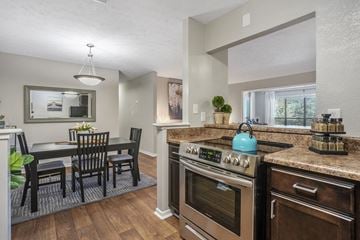 Peachtree Corners apartment for rent - an open kitchen and dining room with a table and chairs and an oven and sink