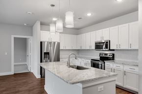 Carrollton apartment for rent - Modern kitchens with stone countertops and tile backsplash at Windsor Castle Hills, Texas