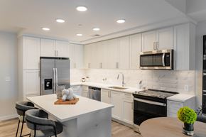 Atlanta apartment for rent - a kitchen with white cabinets and black appliances and a white counter top